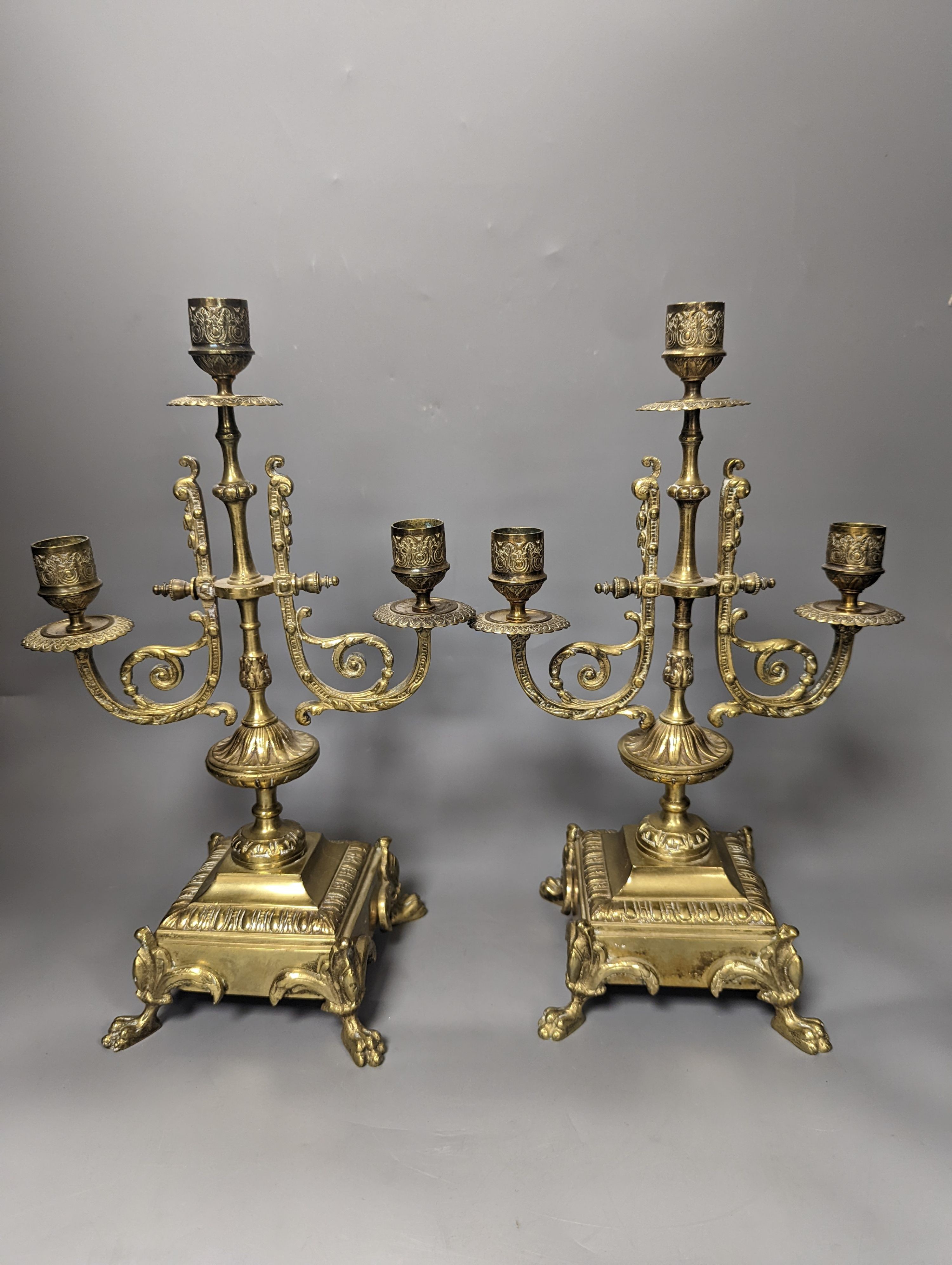 A 19th century French ornate brass clock garniture including a pair of 3 branch candelabra, Clock 42 cms high.